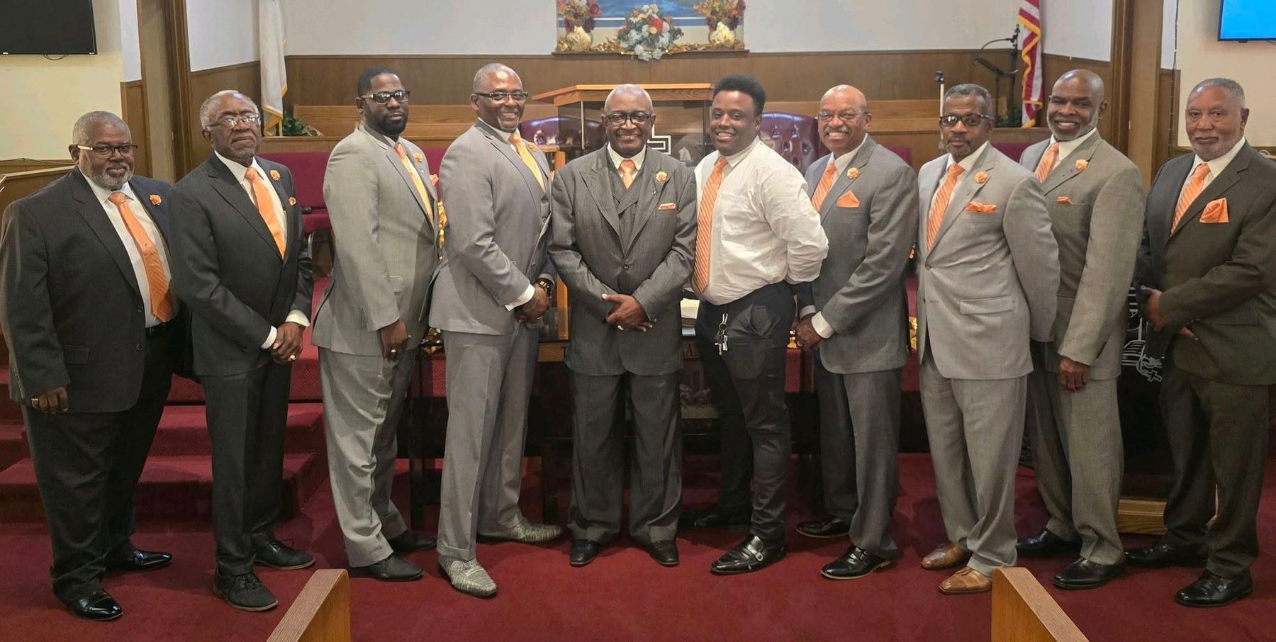The men of Greater Union in gray suits with orange ties