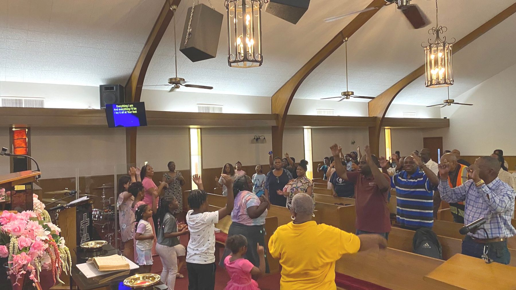 Members of Greater Union lifting their hands in praise inside the sanctuary